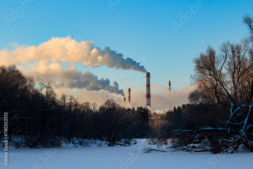 Winter landscape with a view of tall pipes smoking above the boiler station