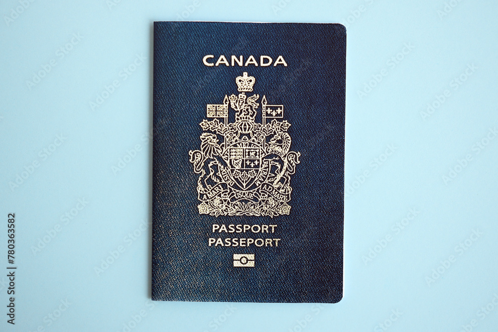 Obraz premium Canadian passport on blue background close up. Tourism and citizenship concept
