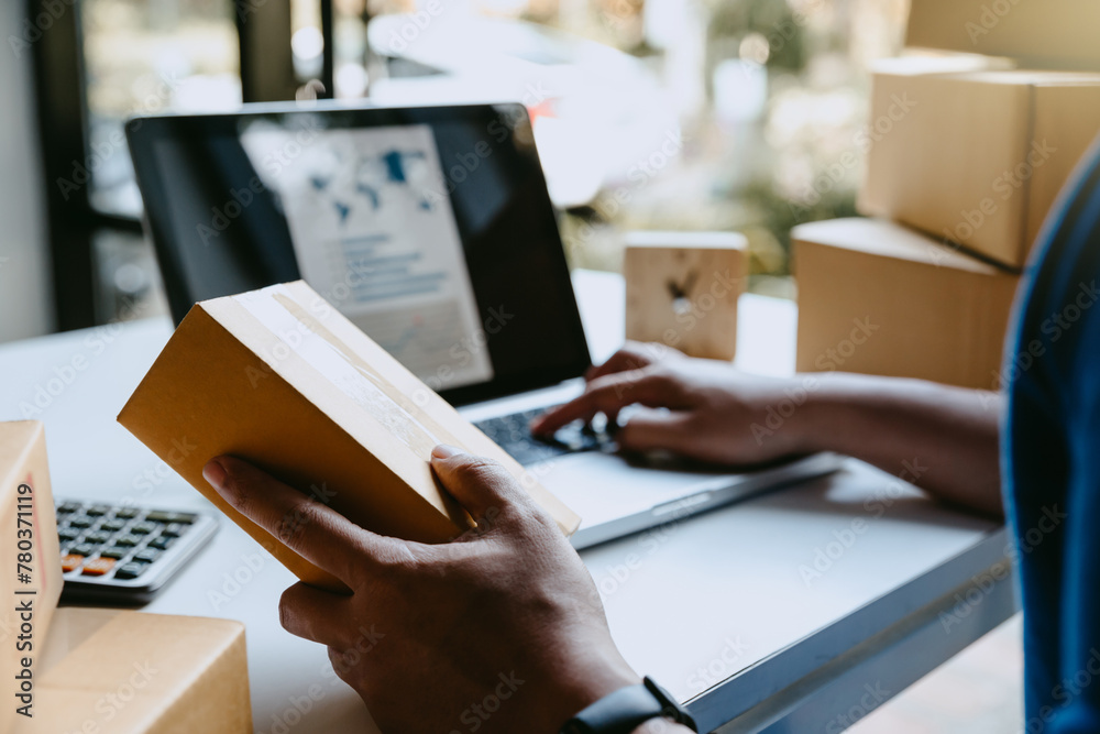 Fototapeta premium Man seller worker online store using laptop with e-Commerce Online orders, online selling concept.