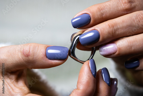 Detailed view of hands with blue nail polish and rings