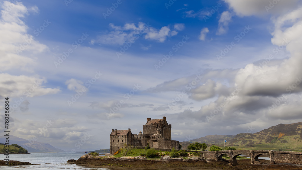 The historic Eilean Donan Castle, framed by a vast sky and the serene loch, embodies the essence of the Scottish landscape and heritage