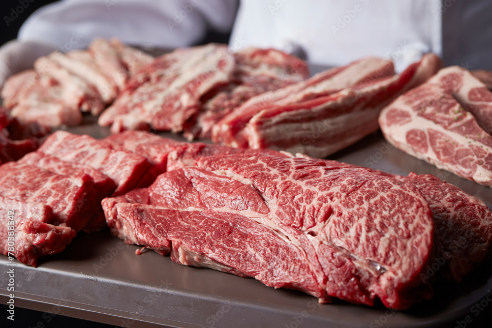 Meat in various parts held by the chef