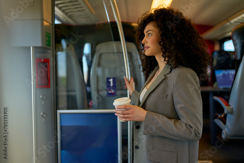 Fashionable female traveler with a coffee cup embracing the slow pace of city transport, gazing out the bus window.