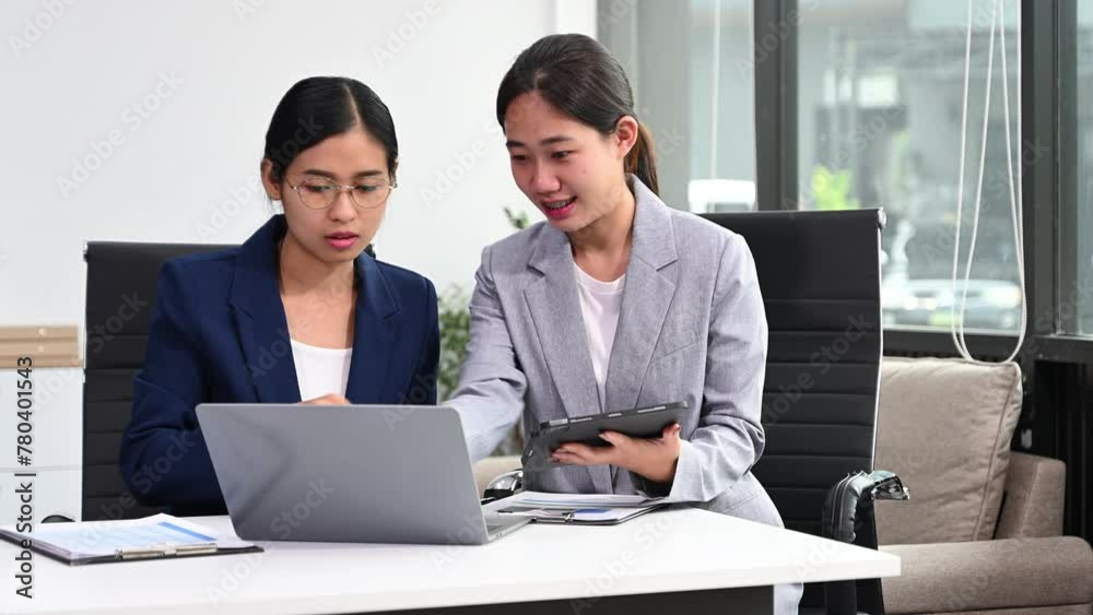 Two business workers talking on the smartphone and using laptop at the office. Two business workers talking on the smartphone and using laptop at the office.
