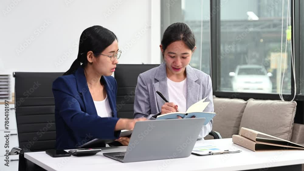 Two business workers talking on the smartphone and using laptop at the office. Two business workers talking on the smartphone and using laptop at the office.
