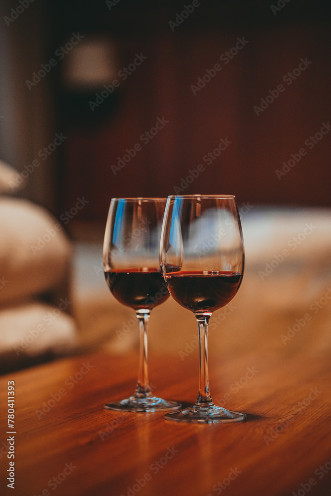 Two glasses filled with red wine, in a cozy apartment Two glasses filled with red wine, in a cozy apartment