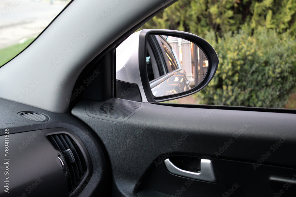 Inside view of car mirror. Look in the rear view mirror of a car. Side rear-view mirror on a car.