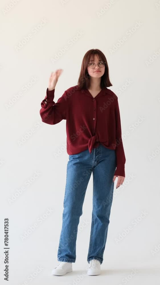 Bored and displeased Caucasian teenage girl showing blah gesture on white background. Chitchat and gossip concept. Vertical video.