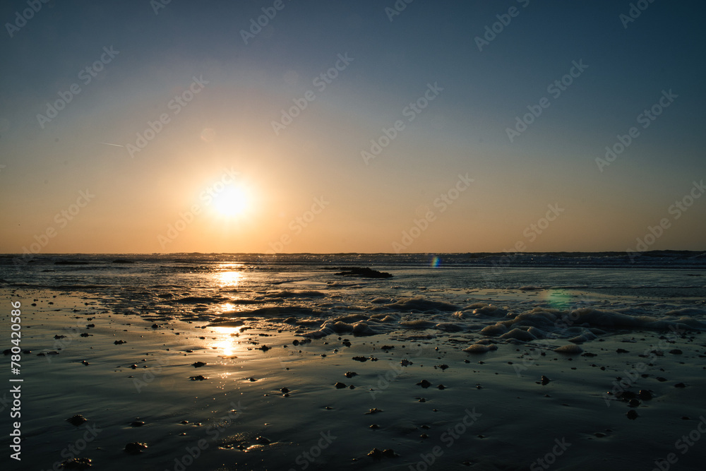 Scenic view of the sun setting and reflecting on the surface of the ocean