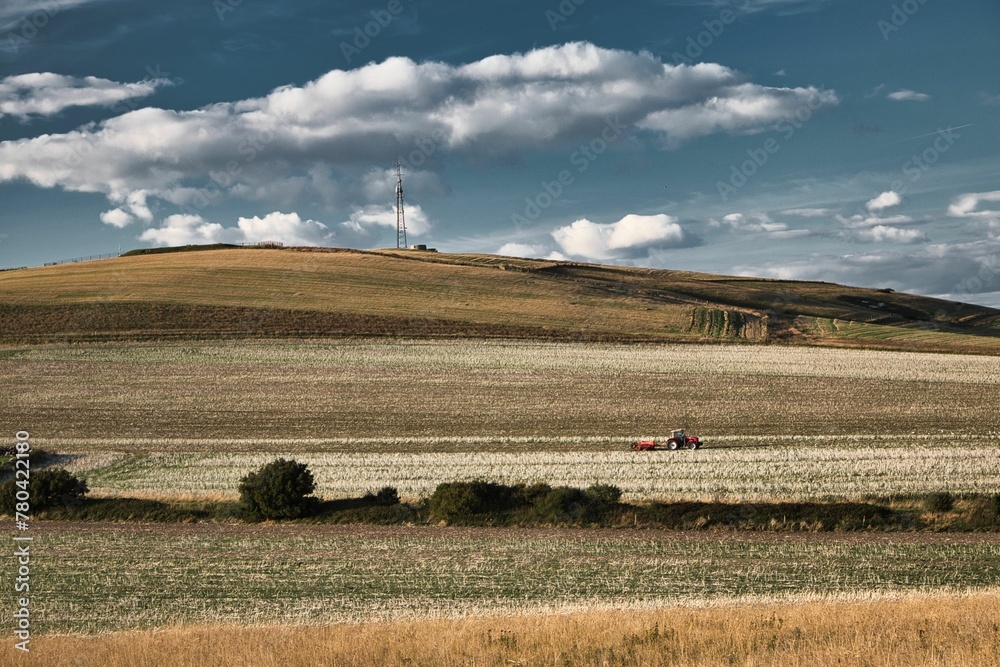 Fototapeta premium Tractor in a field on the isle of Wight under the cloudy sky