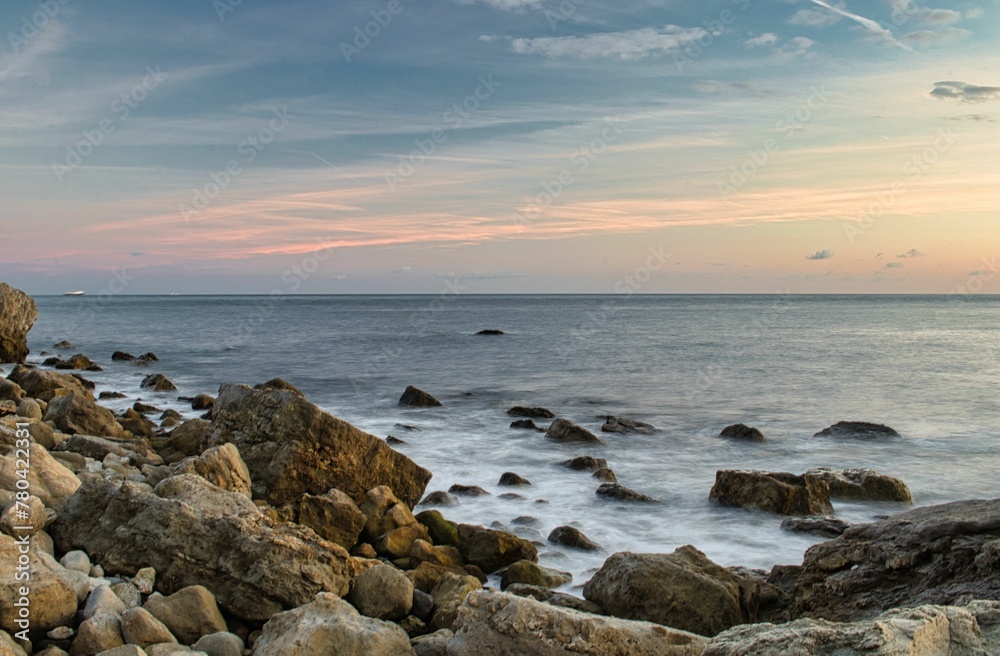 Scenic shot of big stones on the shore of the sea on the Isle of Wight at sunset