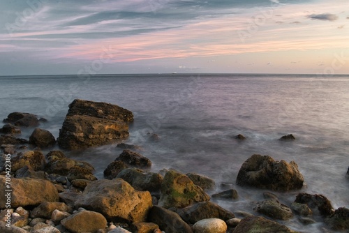 Scenic shot of big stones on the shore of the sea on the Isle of Wight at sunset © Wirestock
