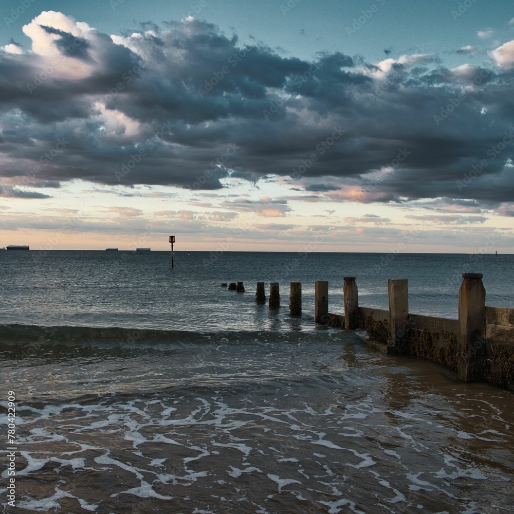 Cloudscape over the wavy sea with breakwaters, Isle of Wight, England