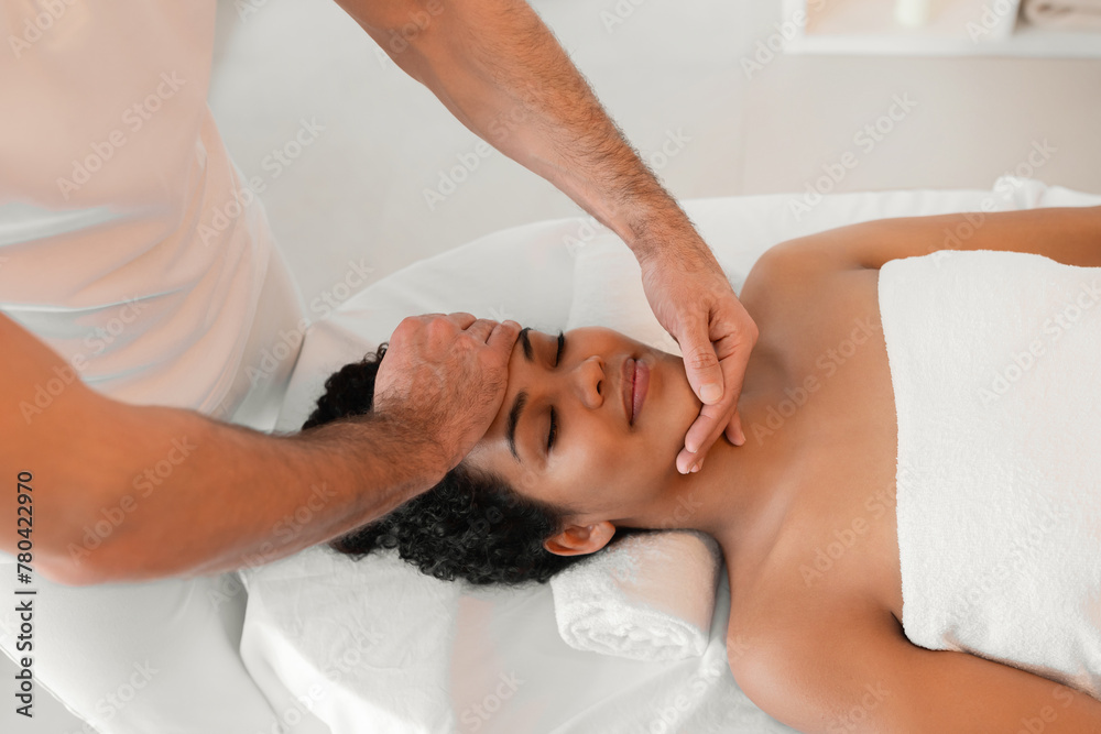 Male masseur giving face massage to woman - obrazy, fototapety, plakaty 