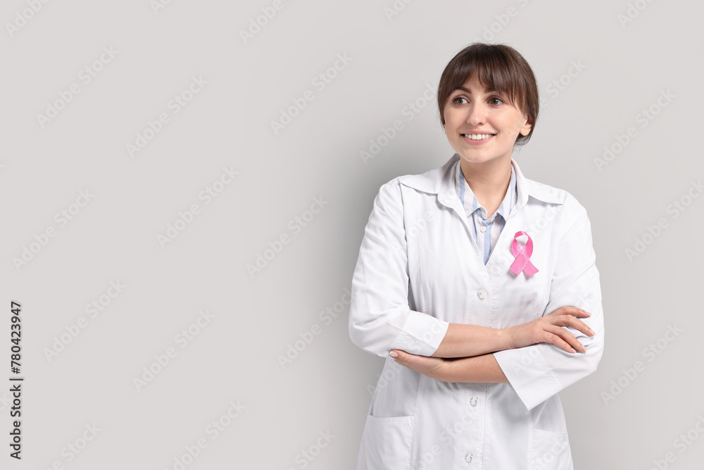 Mammologist with pink ribbon on light grey background, space for text. Breast cancer awareness Mammologist with pink ribbon on light grey background, space for text. Breast cancer awareness