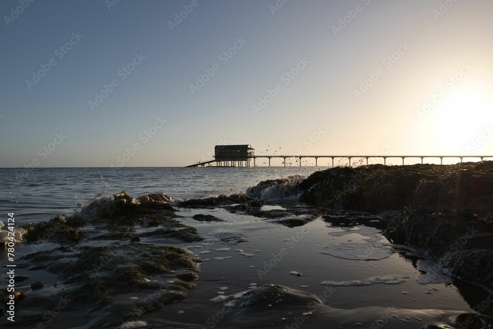 Fototapeta premium Bembridge beach and its lifeboat station in the Isle of Wight against the cloudless sky