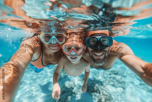 Parents with their son wearing a snorkeling masks dive underwater.