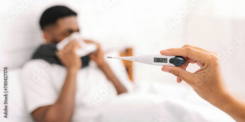 Sick black man with fever lying in bed