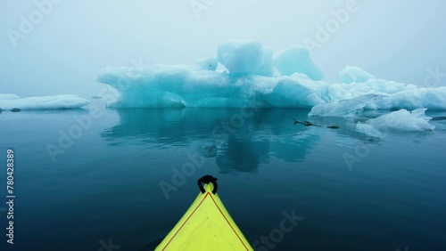 Winter Kayaking in Jökulsárlón the Glacial Lake in Iceland with Iceberg in a Yellow Kayak. Jokulsarlon Icebergs photo