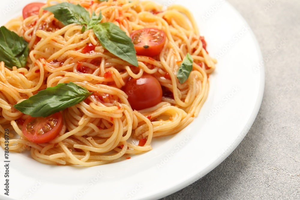 Vegetarian meal. Tasty pasta with fresh tomatoes and basil on light grey table, closeup