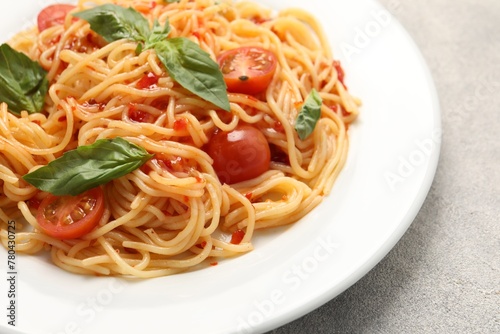 Vegetarian meal. Tasty pasta with fresh tomatoes and basil on light grey table, closeup