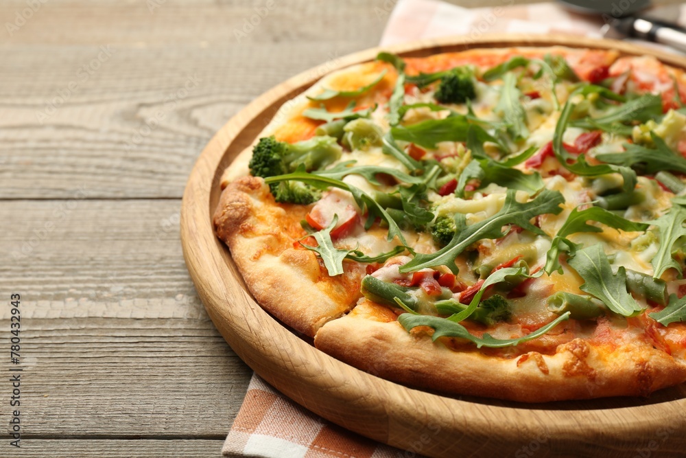 Board with delicious vegetarian pizza on wooden table, closeup. Space for text