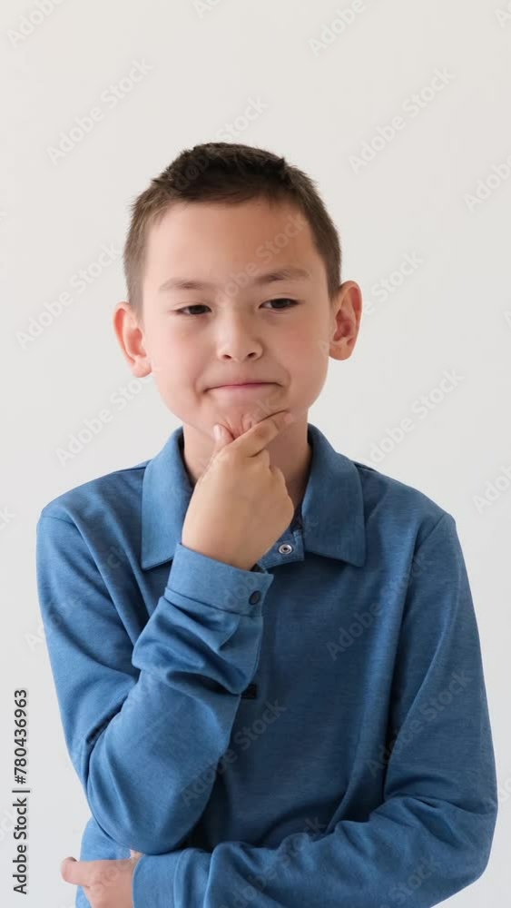 Pensive Asian young boy thinking, searching decision or making choice on white background. Concentration and brainstorming concept. Vertical video.