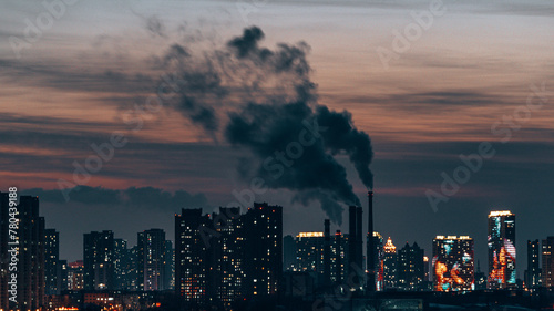 Industrial factory with smoke and modern buildings at sunset