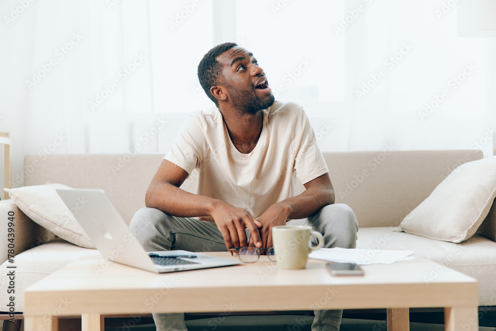 Tired African American Freelancer Working on Laptop in Modern Home Office, Feeling Unhappy and Stressed Tired African American Freelancer Working on Laptop in Modern Home Office, Feeling Unhappy and Stressed