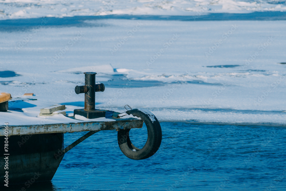 Fototapeta premium Powerful metal mesh with cross shaped and concrete bollard over the blue water