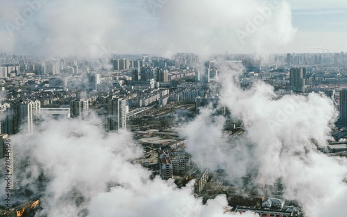 Aerial shot over an industrial city with factories, environment in smoke