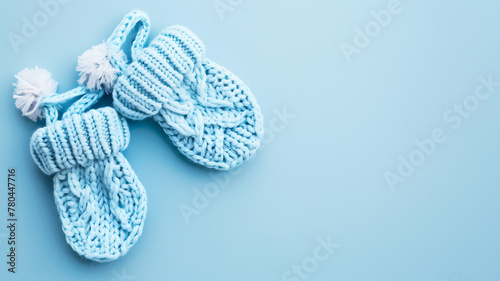 Blue knitted baby shoes on blue background