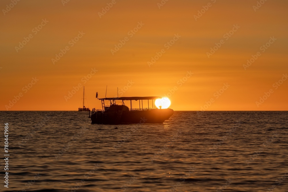 Silhouette of a large boat on the water at sunset