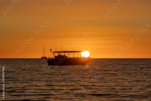 Silhouette of a large boat on the water at sunset