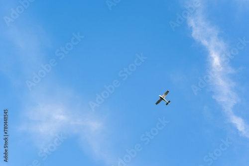 Low angle shot of a plane flying under a blue sky