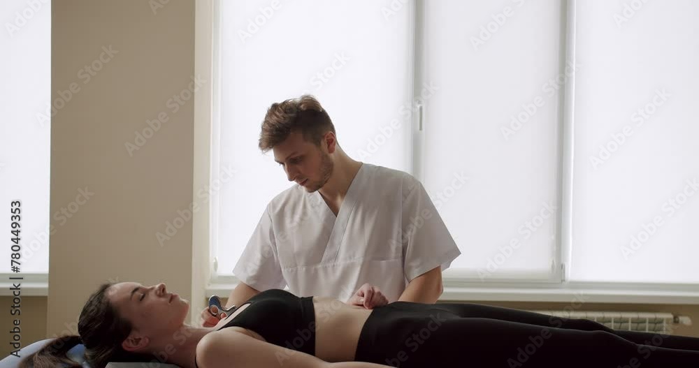 Therapist using IASTM instrument to treat scapular pain, performing fascia release manipulations soft tissue treatment on her neck. IASTM, myofascial Release For Rhomboid And Pain Using Smart Tools