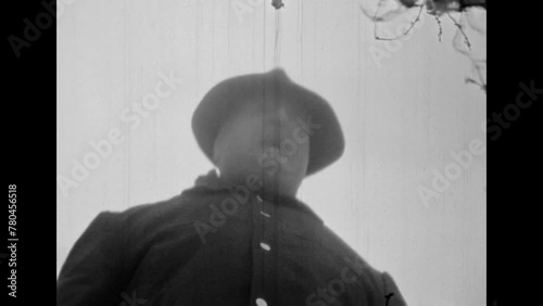 Criminal man silhouette in hat, stockings scary mask on face, close up. Maniac male portrait laughing gloatingly, frighteningly. Evil killer attack. Vintage black white film. Retro crime archive 1980s photo
