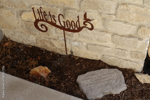 Life is good sign in soil against a brick wall. photo