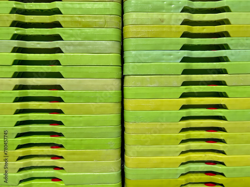 Green plastic boxes for industrial use, folded and stacked to form a pattern.