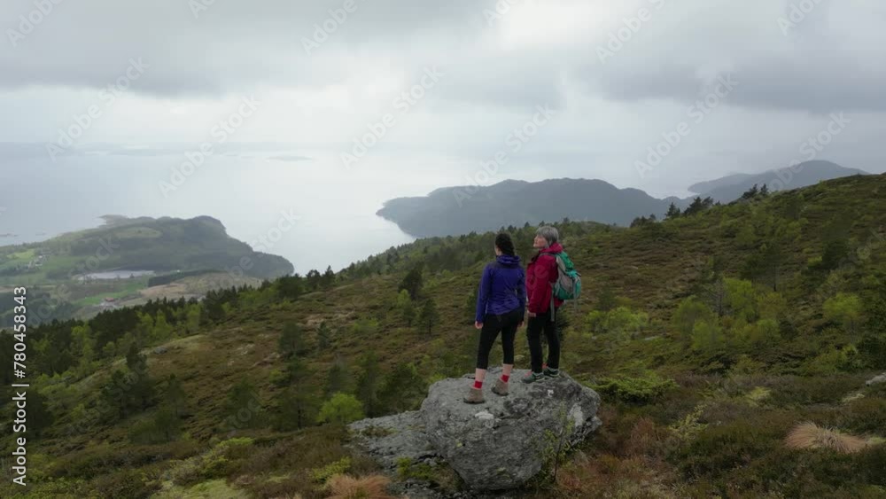 Drone video of mother and daughter at viewpoint near Stolanuten hill top in Nedstrand, Norway Drone video of mother and daughter at viewpoint near Stolanuten hill top in Nedstrand, Norway
