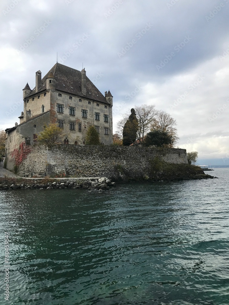 Vertical shot of Yvoire Castle against a lake on a cloudy day in France