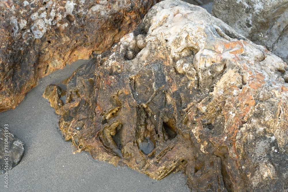 Naklejka premium Golden sunrise over the sea waves with stones on the water