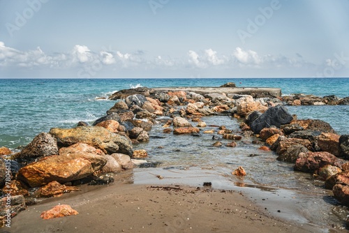 Golden sunrise over the sea waves with stones on the water