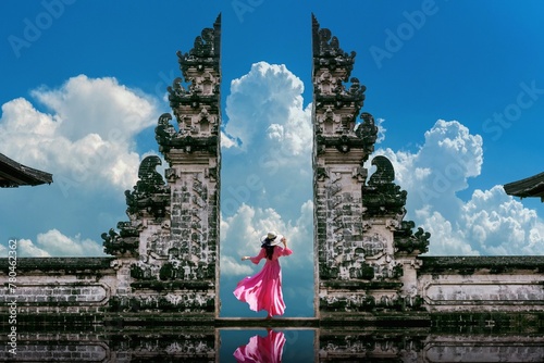 Female with a pink dress standing at Temple gates at Lempuyang Luhur temple in Bali photo