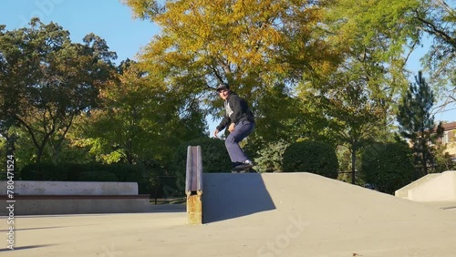 Skateboarder does a halfcab crooked grind on a hubba photo