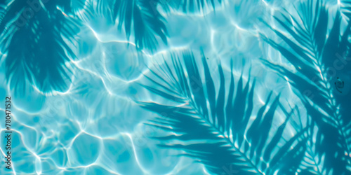 A closeup of  blue water swimming pool with palm leaves  shadows . creating a beautiful summer scene. banner © Nice Seven