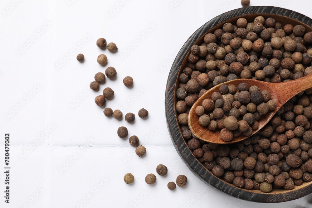Dry allspice berries (Jamaica pepper) on white tiled table, top view. Space for text Dry allspice berries (Jamaica pepper) on white tiled table, top view. Space for text