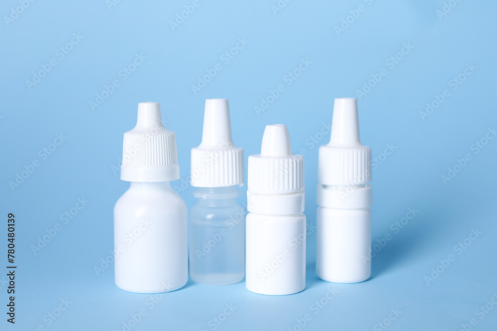 Bottles of medical drops on light blue background Bottles of medical drops on light blue background