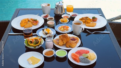 Luxurious breakfast spread at resort with variety of dishes including fruits  pastries  drinks  and hot meals. Exotic dining experience with view.