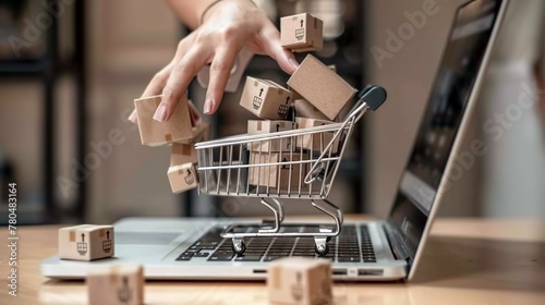 Concetto di shopping online con un carrello pieno di scatole sopra un computer portatile  photo